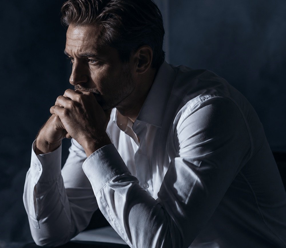 Thoughtful man sitting in a dimly lit room